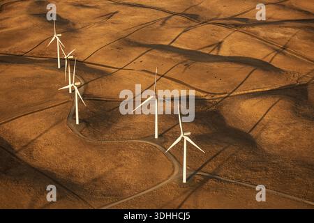 Vista aerea delle turbine eoliche che gettano lunghe ombre sulle colline dorate e ondulate, Altamont Pass, California, Stati Uniti. Foto Stock