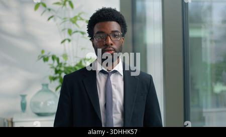 Ritratto in ufficio serio uomo d'affari afro-americano penoso pensare guardando la macchina fotografica fiducioso uomo d'affari etnico uomo d'affari lavoratore Foto Stock