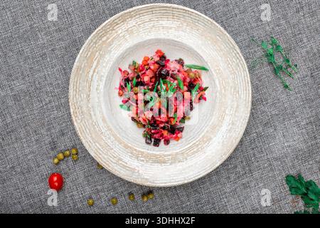 Un colpo d'occhio cattura una vivace porzione di insalata di Vinaigrette fatta in casa, un classico antipasto freddo russo e dell'Europa orientale, presentato in bianco Foto Stock