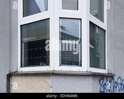Finestra frontale, finestra a baia con pannelli solari utilizzati, generazione di energia sostenibile e insolita negli edifici residenziali, Wuppertal, Germania Foto Stock