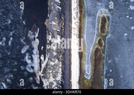 Vista aerea del forte contrasto tra le acque ghiacciate e la strada buia che attraversa il paesaggio, Vik, Mýrdalshreppur, Islanda. Foto Stock