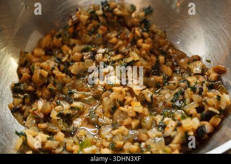 Funghi fritti con cipolle ed erbe aromatiche in un recipiente di metallo. Ripieno preparato per torte o gnocchi. Foto Stock