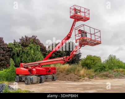 Due piattaforme aeree rosse nell'atmosfera del lotto di costruzione Foto Stock