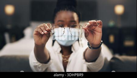 Casa, maschera e donna nera con occhiali per consigli sulla salute, tutorial e dimostrazione in buio. Mostrare, notte e persona con consigli, hack e cornici Foto Stock