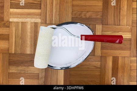 Secchio per utensili per pittura con rullo per pittura e nastro di mascheratura preparato per lavori di ristrutturazione di riparazioni domestiche e decorazioni murali Foto Stock