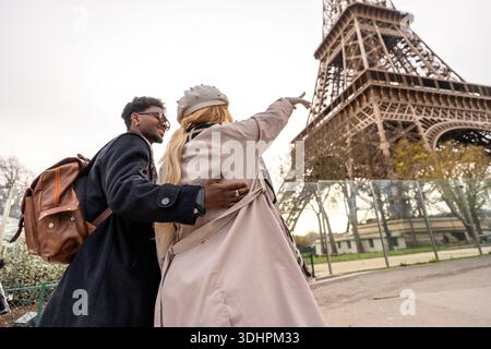 Coppia felice che si goda la vacanza a parigi puntando alla Torre eiffel Foto Stock