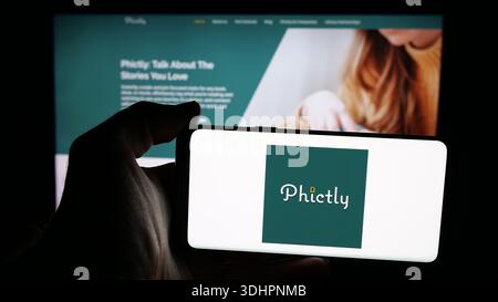 16 dicembre 2025, Germania: In questa foto, una persona ha in mano un telefono cellulare con il logo della società statunitense di app per social media Phictly sullo schermo davanti alla pagina web. (Immagine di credito: © Timon Schneider/SOPA Images via ZUMA Press Wire) SOLO PER USO EDITORIALE! Non per USO commerciale! Foto Stock