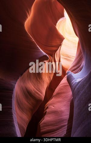 Vista delle lisce e vorticose pareti di arenaria di un canyon inondato di luce calda, che creano un'ipnotica danza di ombre e colori vivaci, Escala Foto Stock