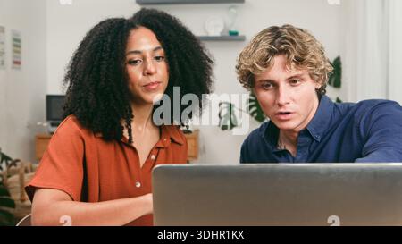 Team diversificato che collaborano con Un notebook in Un ufficio moderno per progetti di avvio e produttività Foto Stock