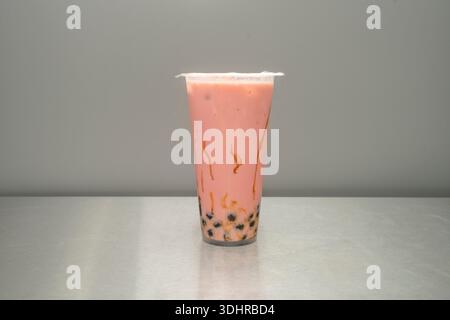 Un bicchiere di bollicine di bacche rosse, con un colore rosso granato profondo e piccoli pezzi di fragola e mirtillo mescolati con perle di tapioca di dimensioni standard Foto Stock