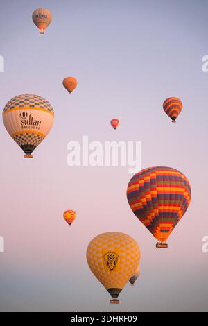Cappadocia, Türkiye - 3 ottobre 2024: Palloni aerostatici fluttuano sul paesaggio roccioso della Cappadocia durante un tour in mongolfiera all'alba Foto Stock