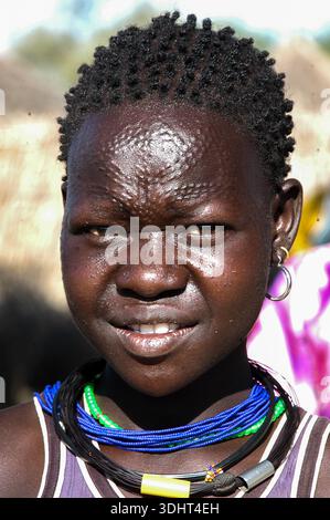 Un ritratto di una giovane donna Karimojong a Kotido, Karamoja, Uganda, che riflette l'abbigliamento tradizionale, l'identità culturale, e la resilienza della pastorale l Foto Stock