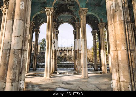 Ammira le alte colonne neoclassiche del Sanatorium Medea in rovina a Tskaltubo, Georgia. Un resort di epoca sovietica in rovina circondato dalla natura e dall'atmosfera Foto Stock
