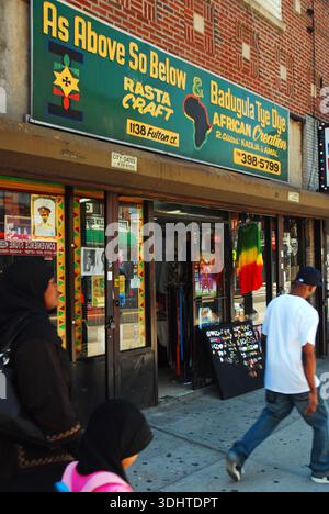 Brooklyn, New York, USA 30 maggio 2010 Una donna in abito tradizionale musulmano passa davanti a un negozio indipendente specializzato in artigianato e regali in stile africano Foto Stock