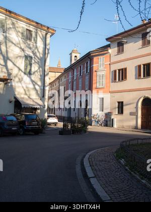 Cremona, Italia 8 gennaio 2026 pittoresca scena di strada a Cremona, Italia, bagnata dalla luce del sole, che presenta un'architettura affascinante e una lontana campana Foto Stock