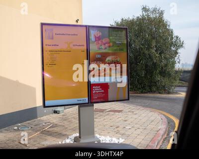 Cremona, Italia 8 gennaio 2026 Un menu digitale presso un McDonald's drive-thru a Cremona, Italia, mostra gli ordini correnti e gli articoli promozionali Foto Stock
