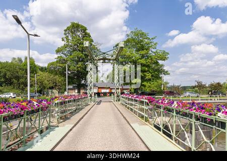 Vecchio ponte levatoio verde con cesti di fiori colorati sul fiume Leie vicino ad Astene nelle Fiandre orientali in Belgio. Foto Stock
