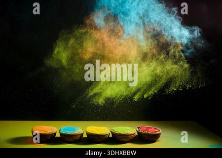 Vivace polvere di colore holi che esplode dalle ciotole Foto Stock