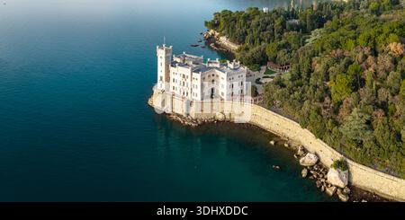 Vista aerea ultra ampia del Castello di Miramare su una scogliera rocciosa con grandi massi e architettura in pietra bianca del mare Adriatico Trieste Italia alta risoluzione Foto Stock