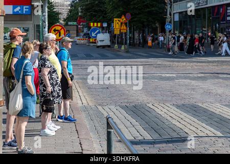 Persone in attesa del via libera per attraversare Mannerheimintie a Helsinki, Finlandia Foto Stock