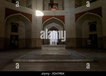 Delhi, India - 30 marzo 2024: L'immagine mostra la camera della tomba centrale all'interno della tomba di Humayun, con il cenotafio principale circondato da nicchie ad arco, pavimento in marmo e finestre a reticolo decorative. Foto Stock