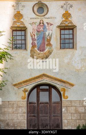 Piccola cappella accanto all'Église Saint-Étienne a Vallouise - la Chapelle des Pènitents (Cappella dei Penitenti). È stata storicamente utilizzata dalla Confraternita dei Penitenti, una confraternita cattolica nota per atti di carità e devozione. La facciata della cappella presenta affreschi decorativi, alcuni dei quali risalgono al XVIII secolo. Nella stagione estiva può talvolta essere utilizzato come spazio espositivo temporaneo. Vallouise, Vallouise-Pelvoux, Hautes-Alpes, Francia Foto Stock