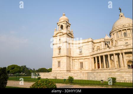 Calcutta, India - 23 marzo 2024: La facciata laterale del Victoria Memorial è mostrata con la sua torre in marmo, il colonnato e dettagli architettonici neoclassici sotto un cielo limpido. Foto Stock