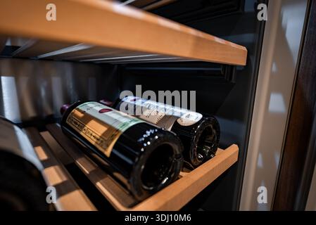 Due bottiglie di vino di prima qualità su spranghe di legno all'interno di un refrigeratore integrato Foto Stock