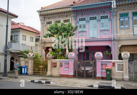 Persone che visitano e posano per delle foto a Koon Seng Road Singapore fuori dalle colorate botteghe Peranakan del quartiere Joo Chiat. Foto Stock