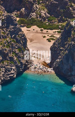 Spiaggia nascosta di Rocky Cove con acque turchesi e litorale affollato per vacanze e viaggi Foto Stock
