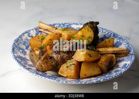 Carne di ossa (turco: Incik), stinco di agnello cotto e piatto di patate Foto Stock