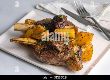 Carne di ossa (turco: Incik), stinco di agnello cotto e piatto di patate Foto Stock