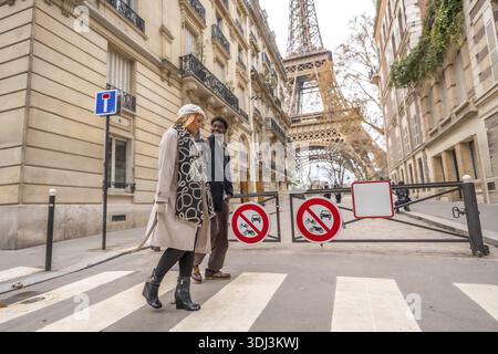 Coppie diverse che camminano felicemente attraverso un passaggio pedonale in un'affascinante strada europea durante l'autunno, godendosi un viaggio romantico con il rimorchio eiffel Foto Stock