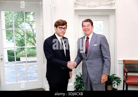 Il presidente degli Stati Uniti Ronald Reagan e il vice direttore per le politiche legali William Barr stringono la mano all'ufficio ovale della Casa Bianca, Washington, D.C., USA, il presidente Ronald Reagan White House Photographic Office, 9 agosto 1983 Foto Stock