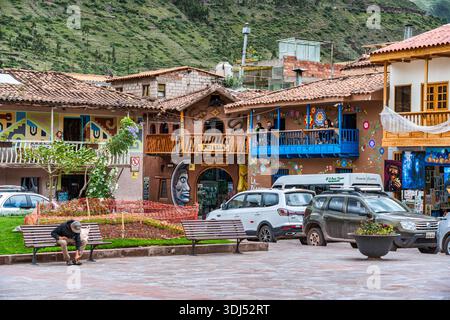 Pisac, Perù - 20 marzo 2025: Colorati edifici coloniali con tradizionali balconi in legno nella piazza principale della città (Plaza Constitucion) di Pisac, in Foto Stock