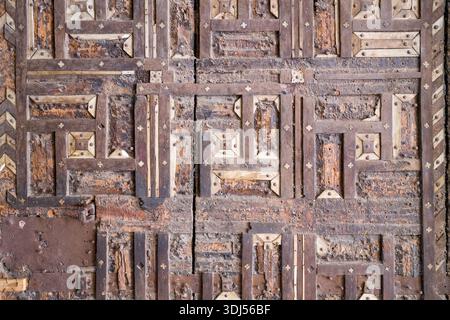 Bundi, India - 20 marzo 2022: Vista ravvicinata di una storica porta in legno al Garh Palace con motivi geometrici a intarsi con elementi in avorio e metallo. Foto Stock