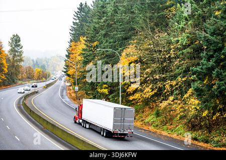 Trattore industriale per semi-camion di grandi dimensioni rosso con cabina estesa per il riposo del conducente del veicolo durante il trasporto di carichi in semirimorchio refrigerato in funzione sull'autum Foto Stock