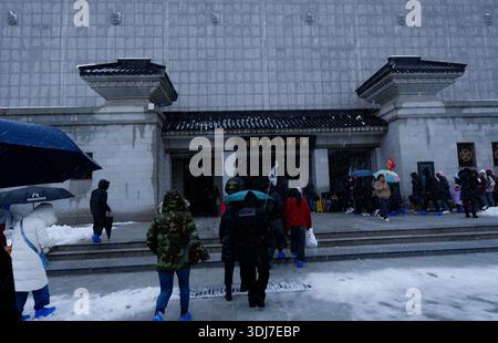 I visitatori camminano attraverso la neve che cade verso l'ingresso del Museo del Mausoleo dell'Imperatore Qinshihuang in un giorno d'inverno Foto Stock
