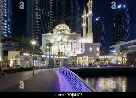 Dubai Marina, Emirati Arabi Uniti - 13 marzo 2025: Dubai Marina dispone di una moschea e di moderni grattacieli illuminati di notte, con un wal sul lungomare Foto Stock