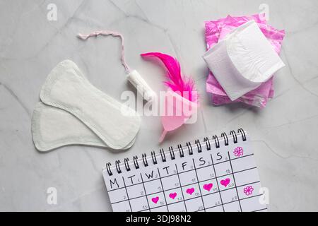Calendario mestruazioni con tamponi di cotone. Protezione igienica delle donne. Giorni critici per le donne. Set di tamponi da donna per igiene personale e femminile Foto Stock
