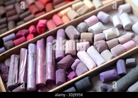 Colori brillanti di gesso pastello tenue. Scatola di legno aperta di pastelli morbidi vista ravvicinata, forniture d'arte multicolore disposte in file. Set di pastelli morbidi Foto Stock
