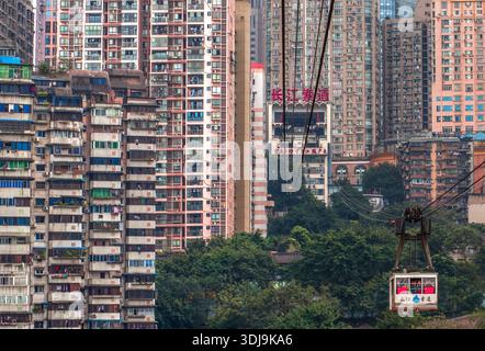 Con uno sfondo di edifici residenziali, vediamo la funivia di Chongqing che attraversa il fiume Yangtze Foto Stock