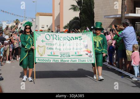Orihuela Costa, Spagna - 17 marzo 2024: Sfilata del giorno di San Patrizio. Le donne in costumi verdi tengono striscioni da parata a Cabo Roig Foto Stock