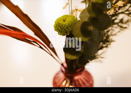 Composizione floreale Moody con garofani arancioni e crisantemi verdi. Composizione botanica romantica in stile cinematografico. Fiori da sposa. Foto Stock