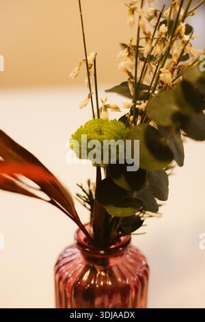 Composizione floreale Moody con garofani arancioni e crisantemi verdi. Composizione botanica romantica in stile cinematografico. Fiori da sposa. Foto Stock