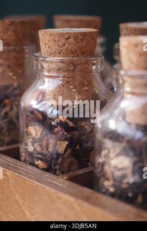 I barattoli contenenti erbe e spezie essiccate si trovano su un ripiano di legno Foto Stock