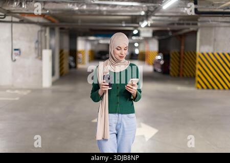 Donna in Hijab che usa il telefono Foto Stock