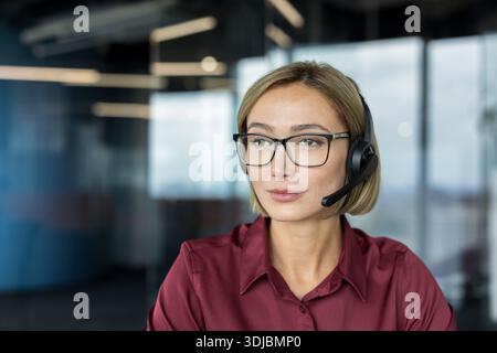 Donna d'affari che indossa cuffie e occhiali in ufficio, fornendo un servizio clienti dedicato, supporto tecnico e assistenza di consulenza online Foto Stock