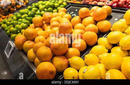 Primo piano di limoni, arance e limoni sullo scaffale del supermercato. Foto Stock