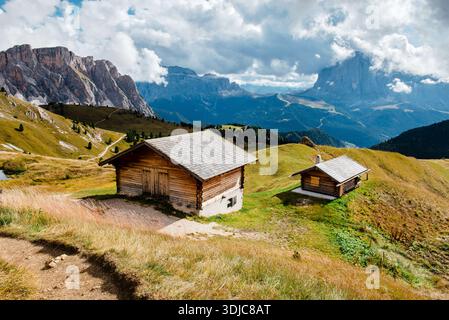 Capanne rustiche in legno incastonate nel suggestivo paesaggio delle Dolomiti di Seceda Foto Stock